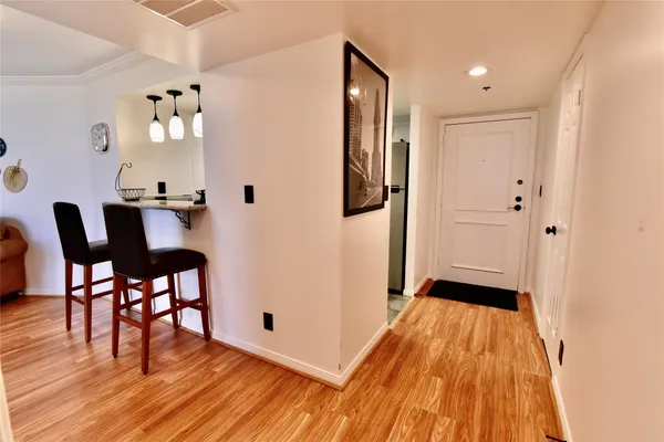 a view of a hallway with wooden floor a chandelier