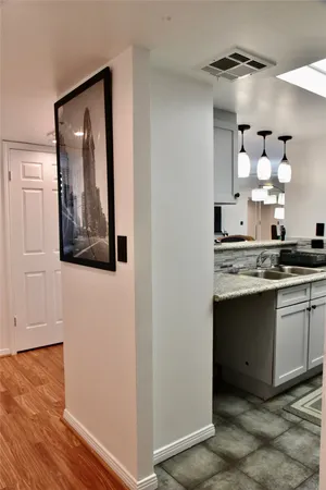a view of a hallway with wooden floor and cabinets