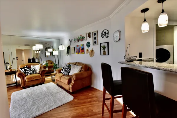 a living room with furniture kitchen view and a large mirror