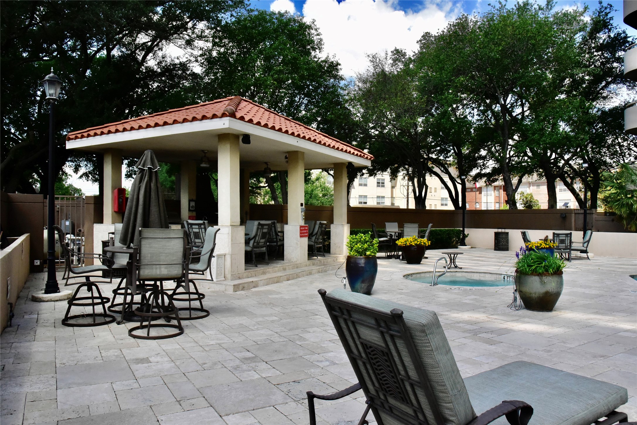 3525 Sage Road, Unit 701 Houston, TX 77056 - Photo 42 of 48 a view of a patio with table and chairs potted plants and large tree