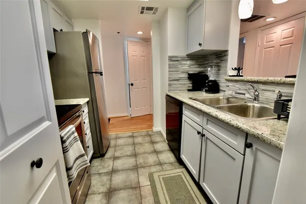 a kitchen with a sink a refrigerator a washer and dryer