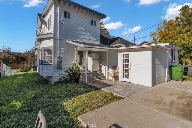 a view of a house with backyard and sitting area