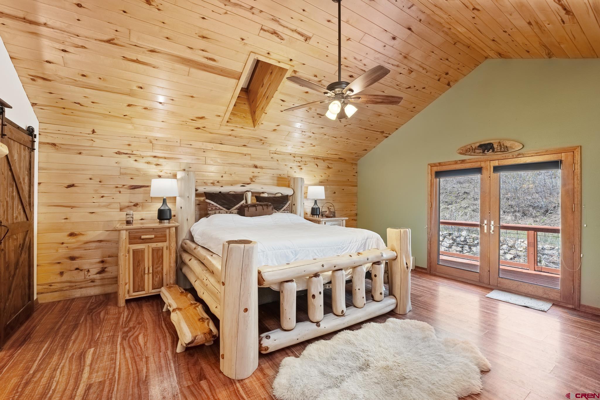 26 Severn Peak Road Bayfield, CO 81122 - Photo 21 of 36 a bedroom with a bed next to a large window with wooden floor