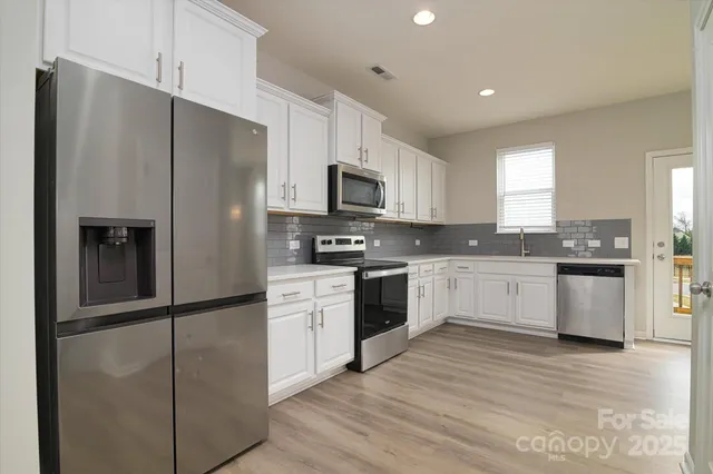 a kitchen with granite countertop white cabinets and a sink
