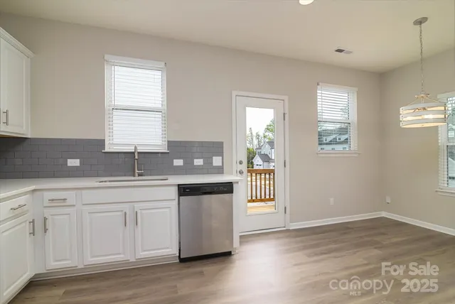 a kitchen with a sink white cabinets and stainless steel appliances