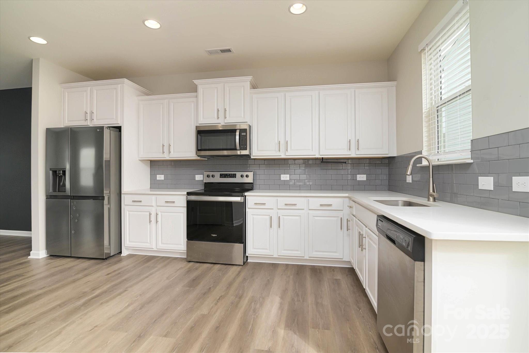 13304 Porter Creek Road Charlotte, NC 28262 - Photo 16 of 22 a kitchen with a sink white cabinets and stainless steel appliances