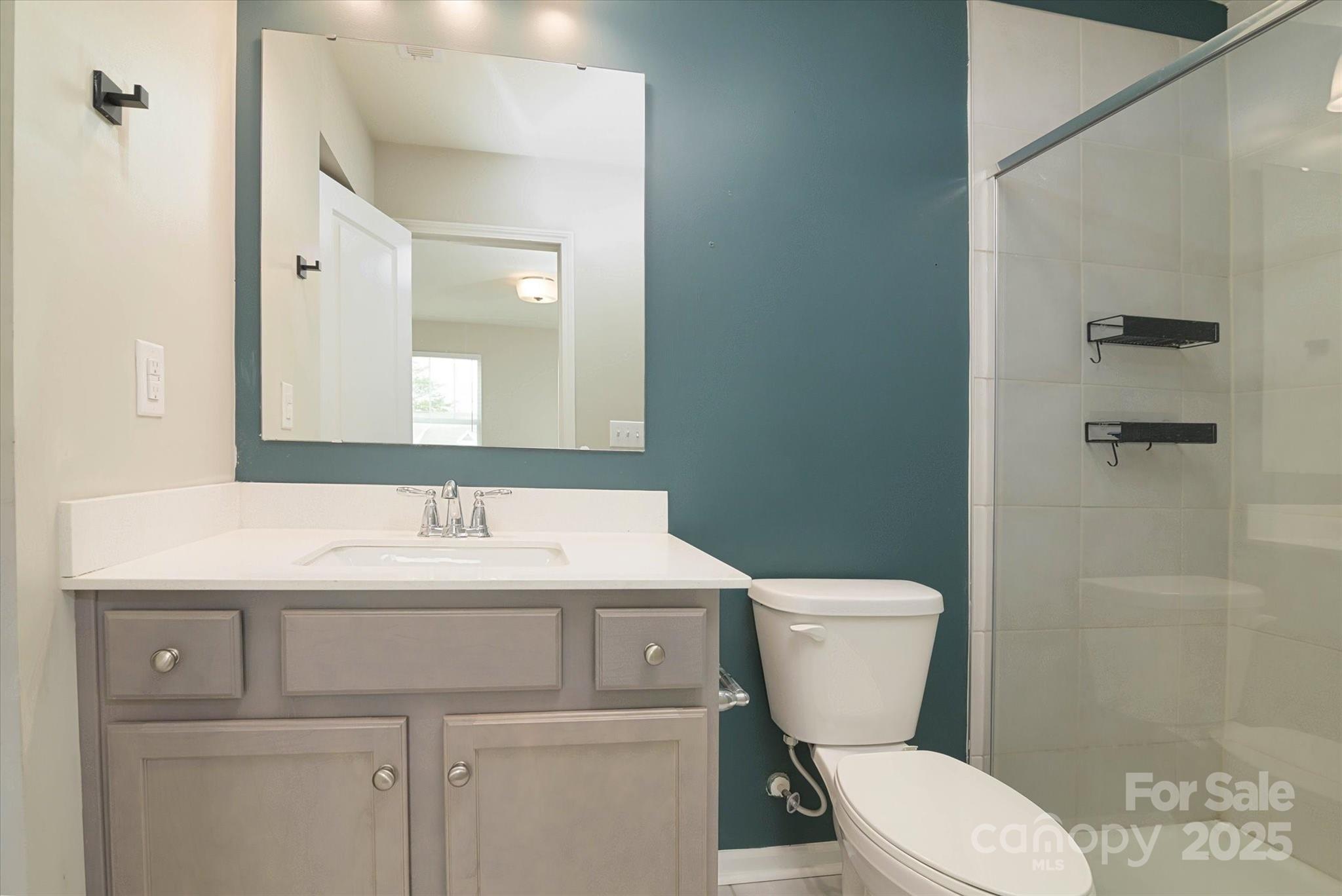 13304 Porter Creek Road Charlotte, NC 28262 - Photo 19 of 22 a bathroom with a toilet a sink and mirror