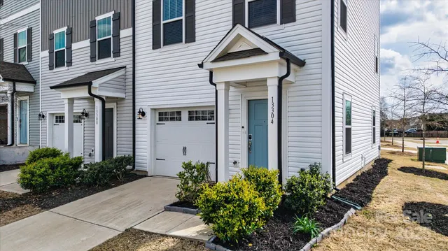 a view of a white house next to a yard