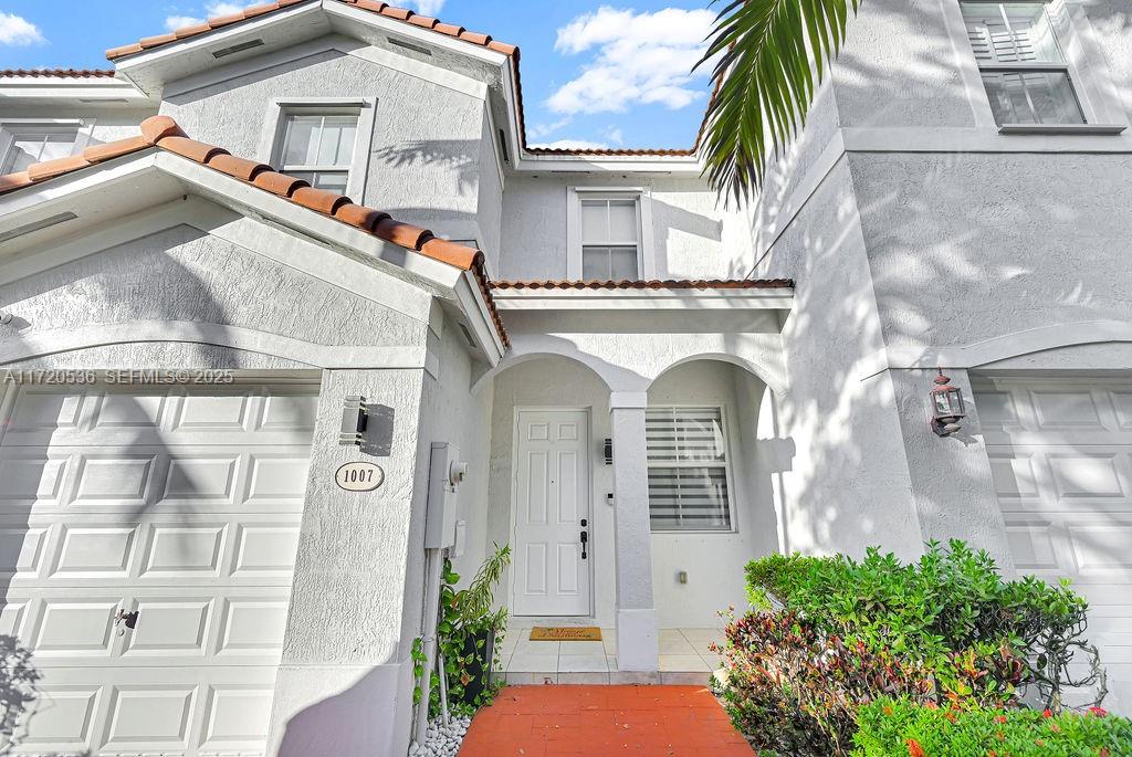 1007 Northeast 208th Street, Unit 1007 Miami, FL 33179 - Photo 2 of 68 a view of a white building among the palm trees