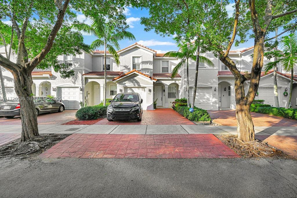 1007 Northeast 208th Street, Unit 1007 Miami, FL 33179 - Photo 37 of 68 a front view of a house with a yard and garage