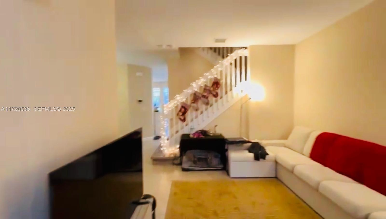 1007 Northeast 208th Street, Unit 1007 Miami, FL 33179 - Photo 38 of 68 a living room with furniture and a lamp