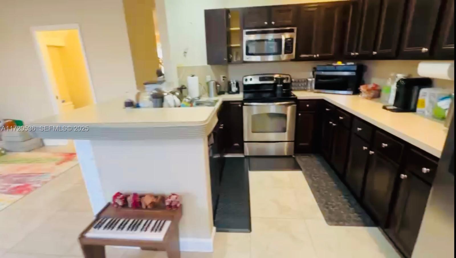 1007 Northeast 208th Street, Unit 1007 Miami, FL 33179 - Photo 44 of 68 a kitchen with a sink appliances and cabinets