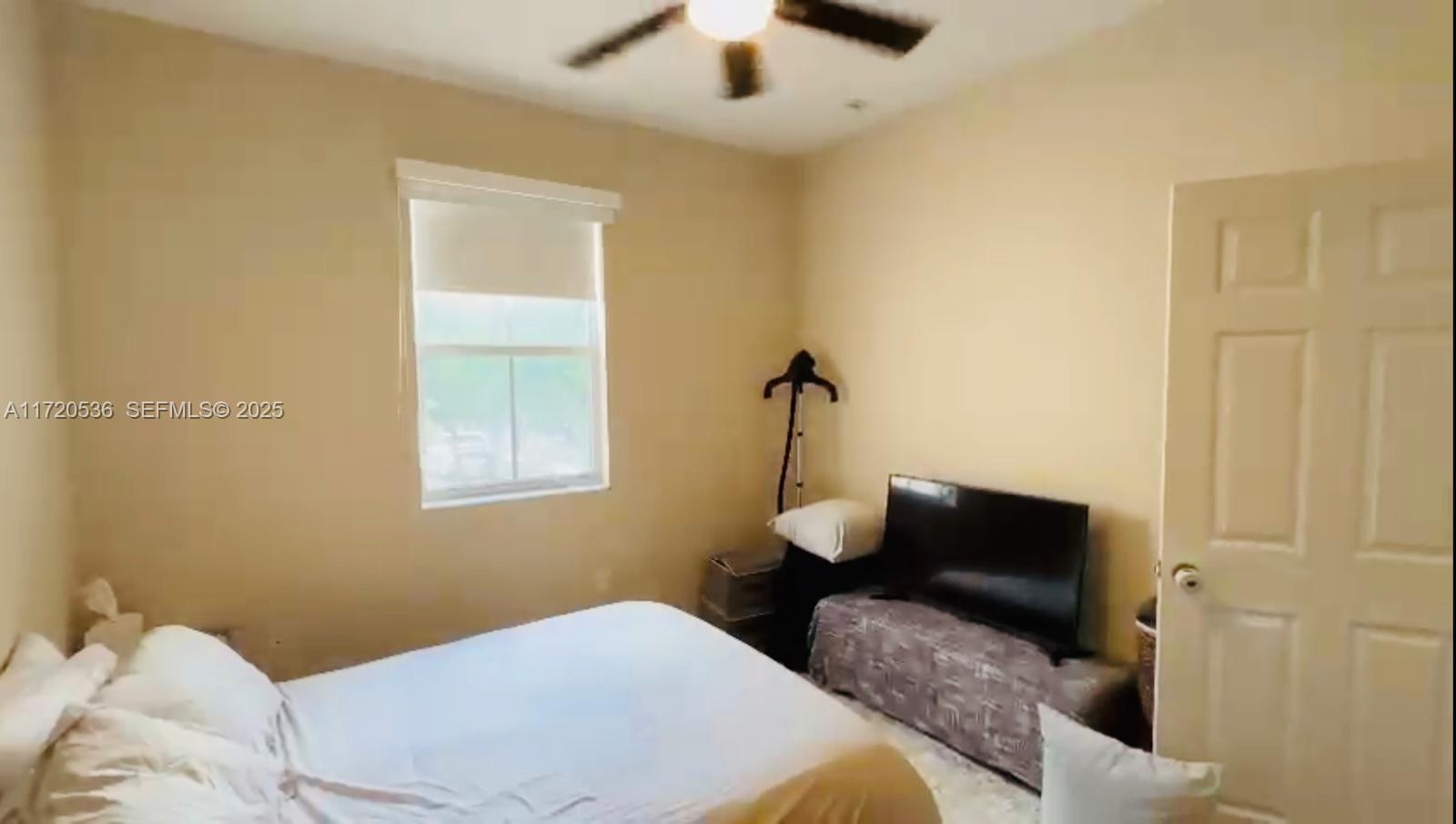 1007 Northeast 208th Street, Unit 1007 Miami, FL 33179 - Photo 49 of 68 a bedroom with a bed and a chandelier