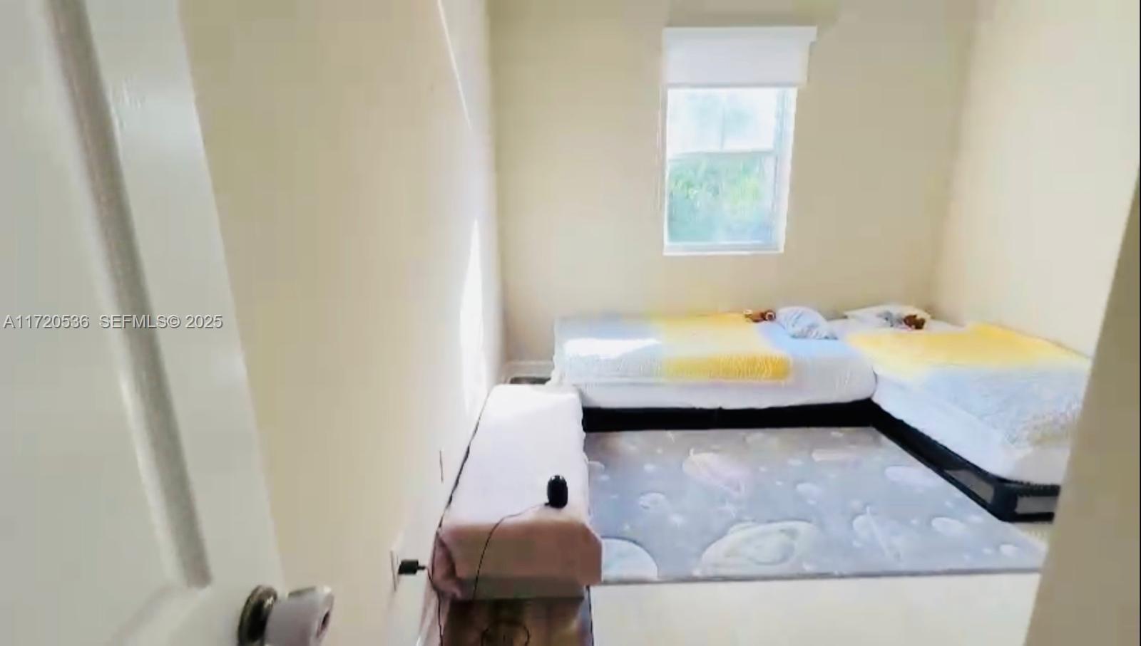 1007 Northeast 208th Street, Unit 1007 Miami, FL 33179 - Photo 50 of 68 a bed room with a bed and a window