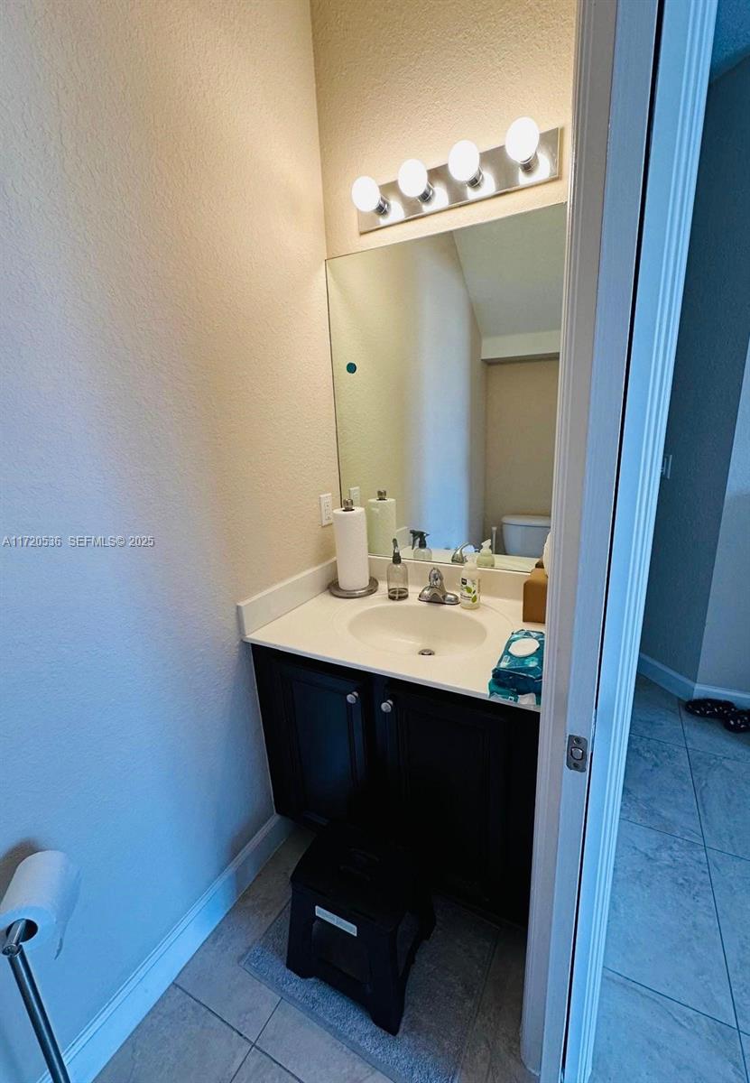 1007 Northeast 208th Street, Unit 1007 Miami, FL 33179 - Photo 58 of 68 a bathroom with a sink and a mirror