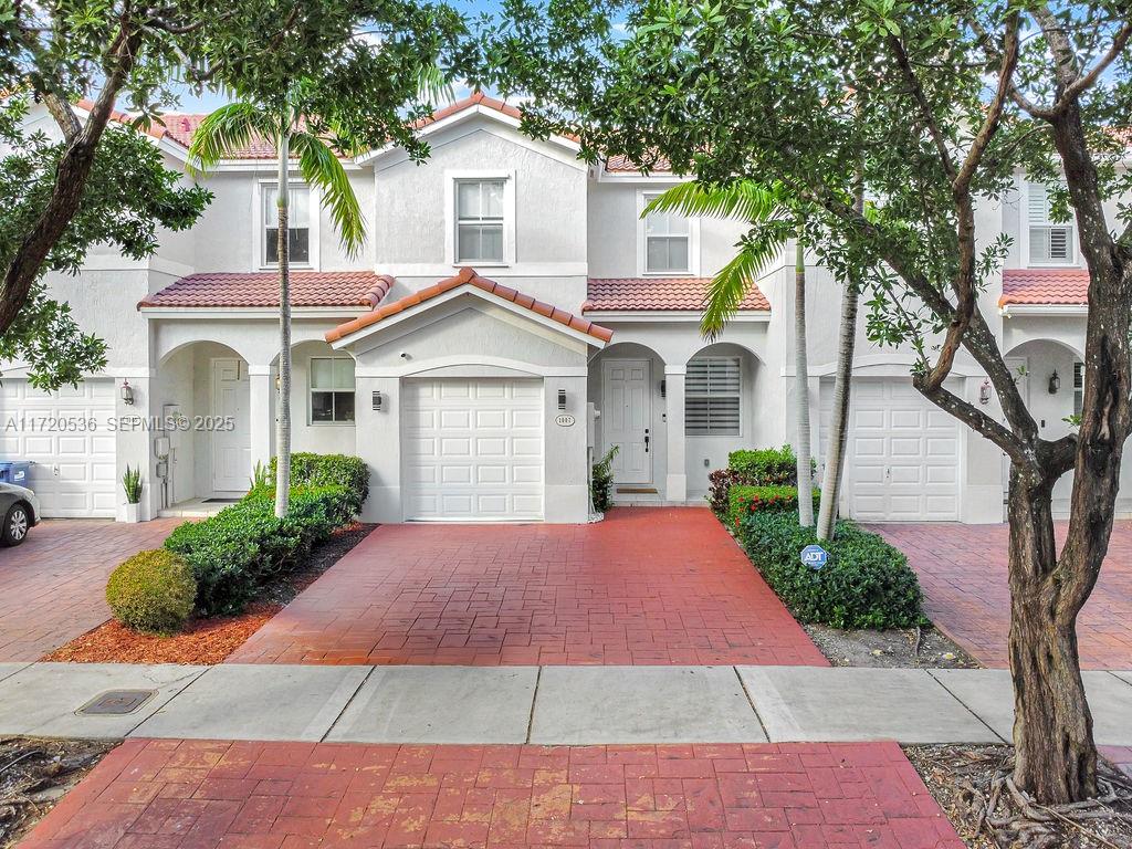 1007 Northeast 208th Street, Unit 1007 Miami, FL 33179 - Photo 10 of 68 a front view of a house with a yard and garage