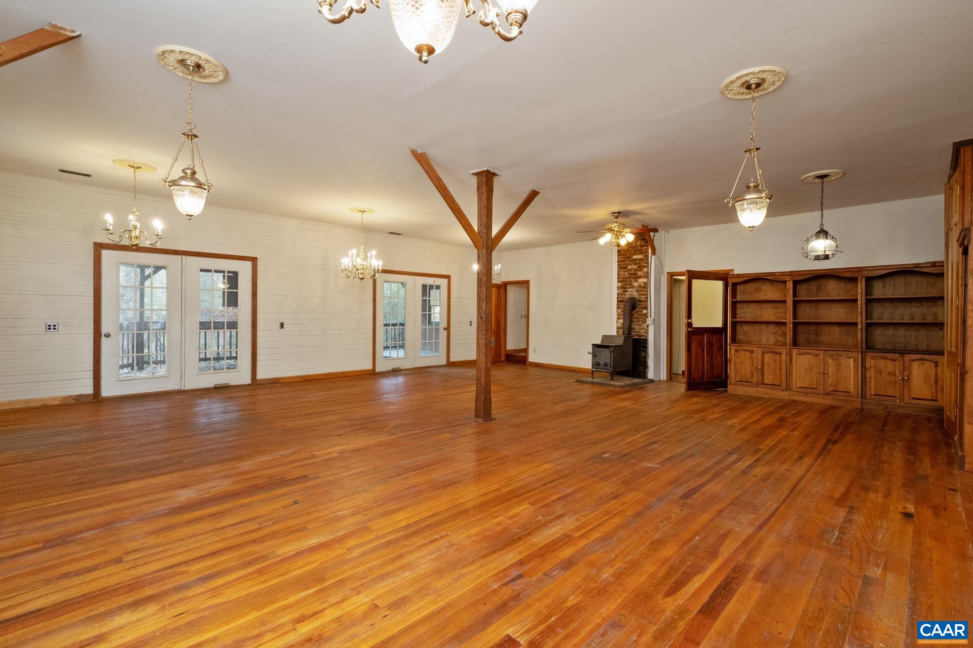122 Seville Road Rochelle, VA 22738 - Photo 7 of 40 an empty room with wooden floor and chandelier