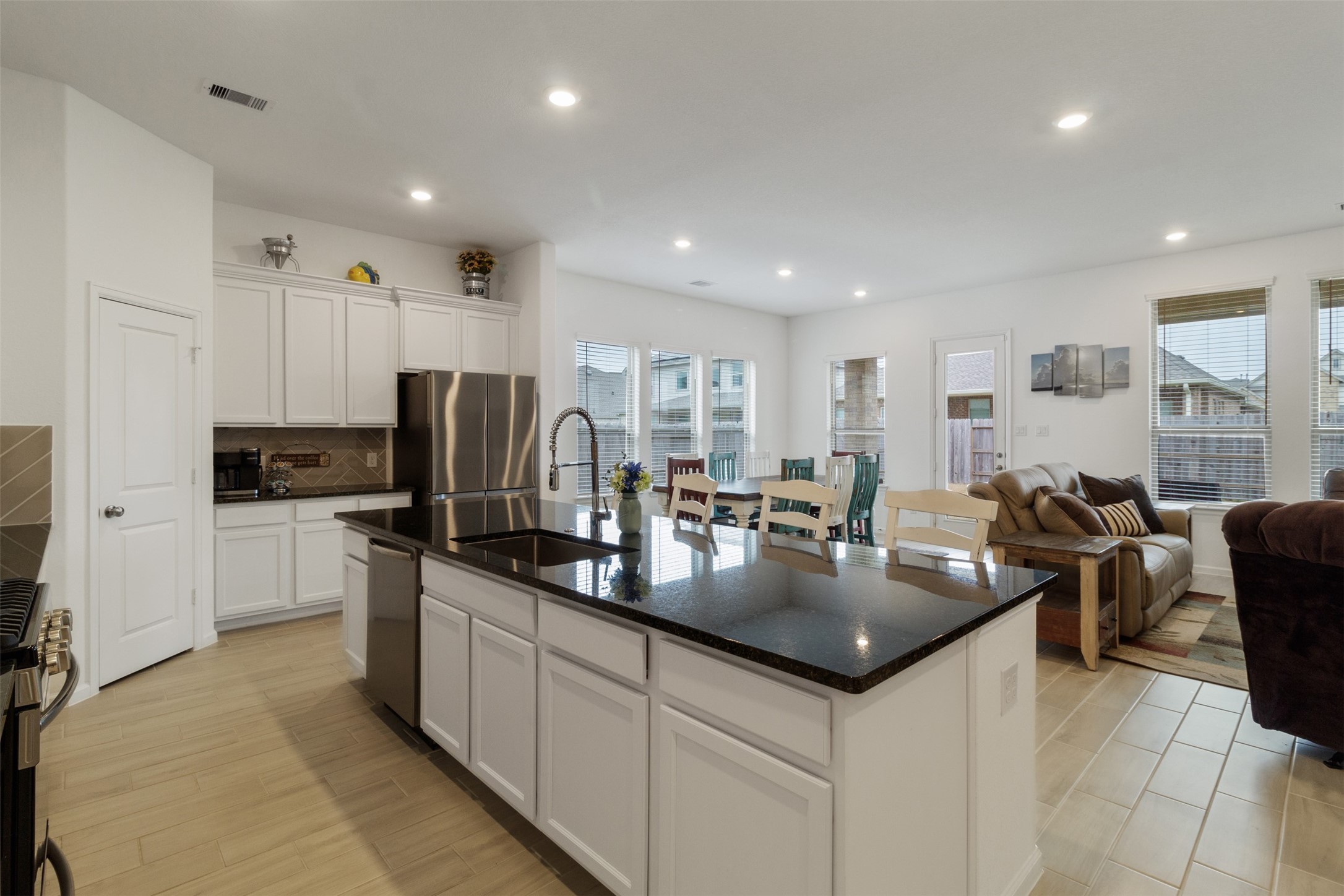 a kitchen with stainless steel appliances granite countertop a sink a stove and a refrigerator