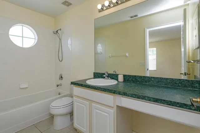 a bathroom with a granite countertop sink toilet and a mirror