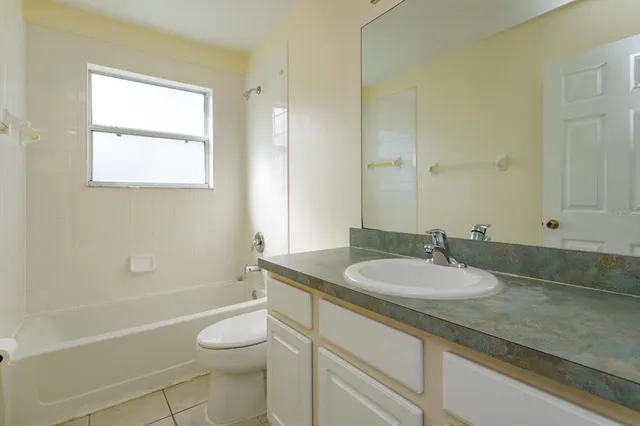 a bathroom with a granite countertop sink toilet a large mirror a bathtub and shower