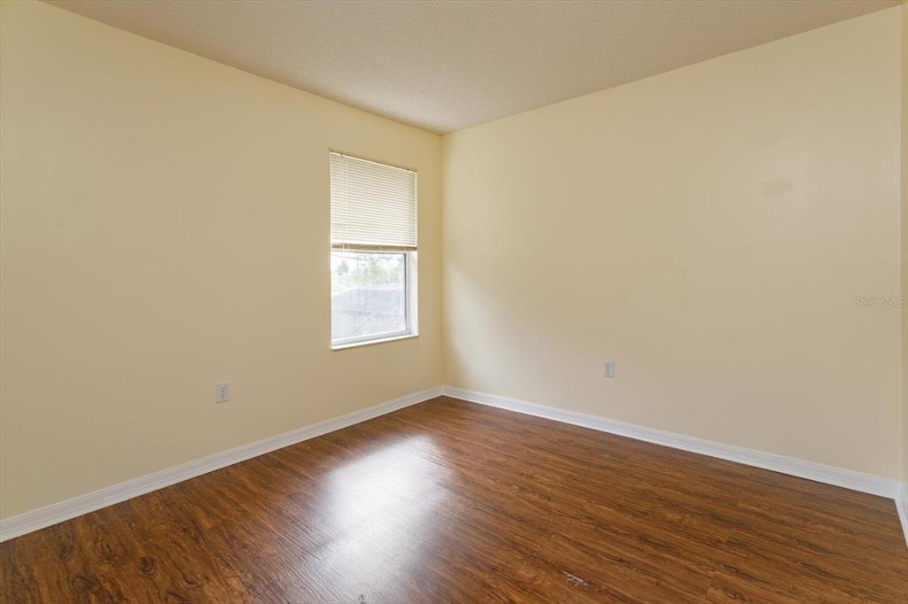 2833 Kokomo Loop Haines City, FL 33844 - Photo 23 of 30 a view of an empty room with wooden floor and a window