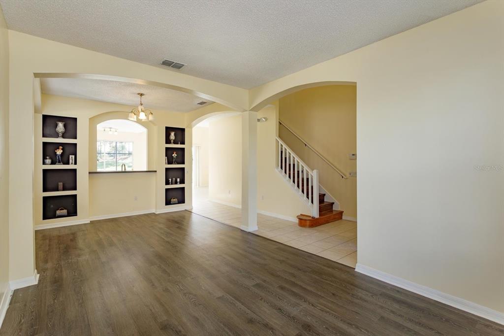 2833 Kokomo Loop Haines City, FL 33844 - Photo 4 of 30 a view of an empty room with wooden floor and kitchen view