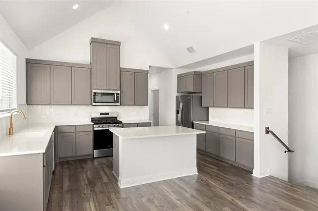 a kitchen with stainless steel appliances a sink stove and refrigerator