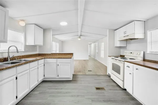 a kitchen with granite countertop white cabinets and white appliances