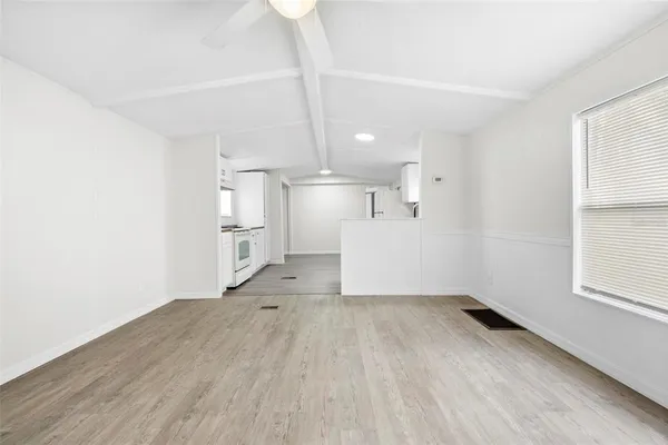 a big room with wooden floor and windows