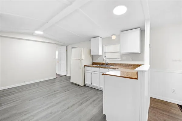 a kitchen with granite countertop white cabinets and white appliances