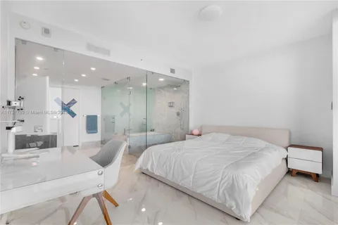 a bedroom with a large bed and a large window