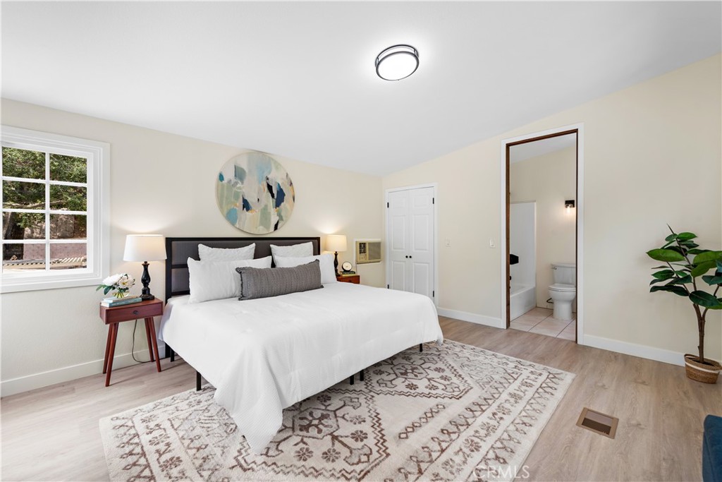 29229 Hazel Bell Drive Silverado, CA 92676 - Photo 26 of 39 a bedroom with a large bed and a wooden floor