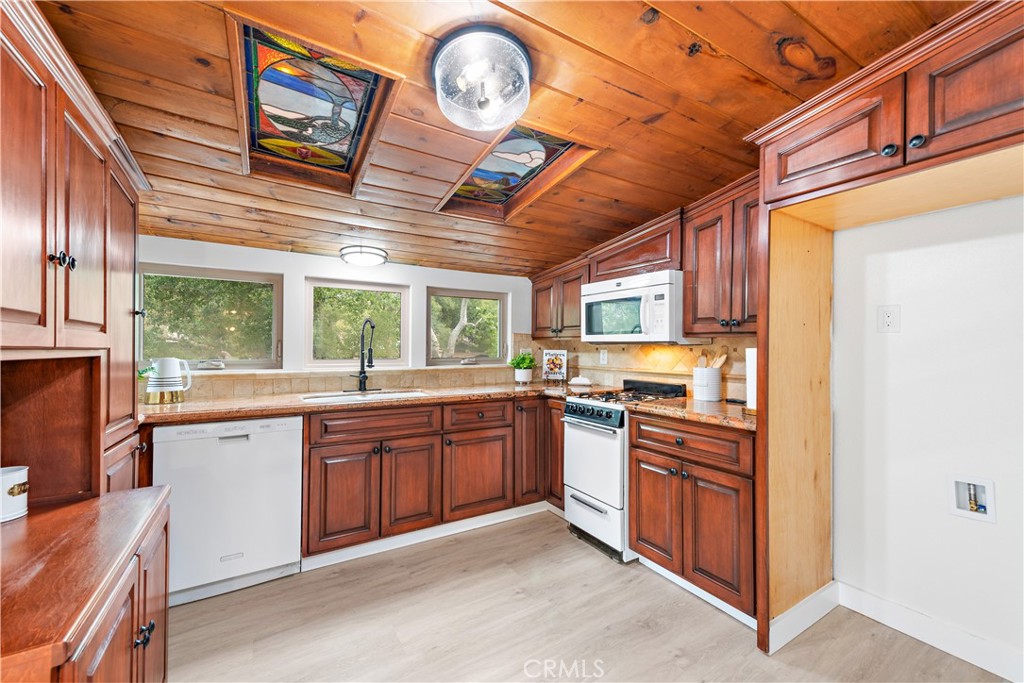 29229 Hazel Bell Drive Silverado, CA 92676 - Photo 9 of 39 a kitchen with stainless steel appliances granite countertop a stove a sink and a microwave
