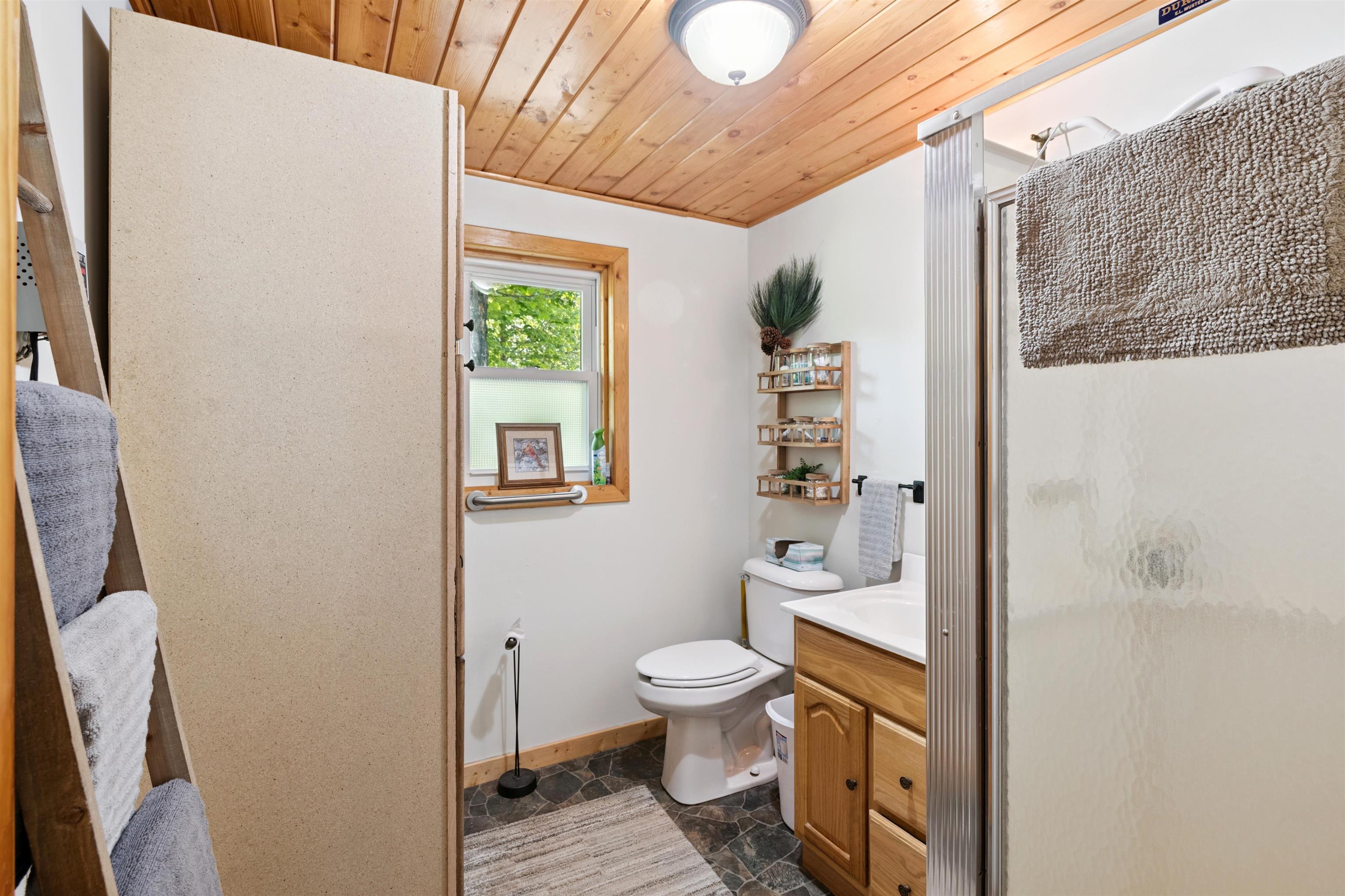 48840 Old Grade Road Cable, WI 54821 - Photo 12 of 22 Bathroom with a shower stall, vanity, wooden ceiling, and stone finish flooring