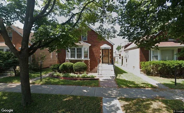 a front view of a house with a yard and potted plants