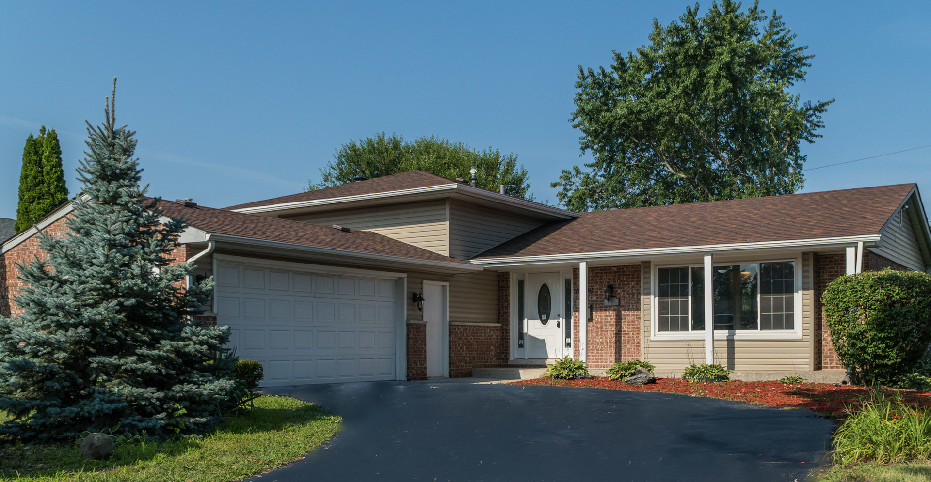 18406 Bock Road Lansing, IL 60438 - Photo 1 of 20 a front view of a house with a garden and plants