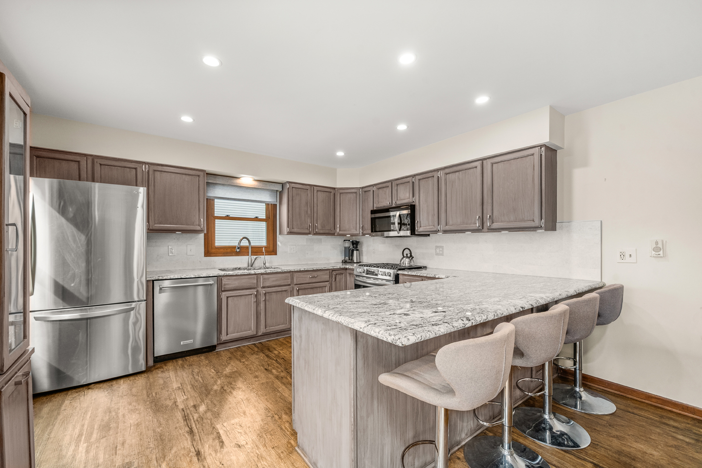 540 Parkside Drive Elburn, IL 60119 - Photo 12 of 38 a kitchen with stainless steel appliances granite countertop a table chairs sink refrigerator and microwave
