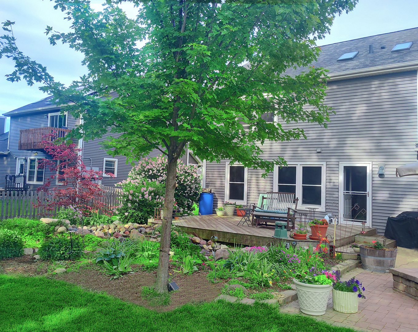 540 Parkside Drive Elburn, IL 60119 - Photo 5 of 38 a view of a patio with table and chairs potted plants and large tree
