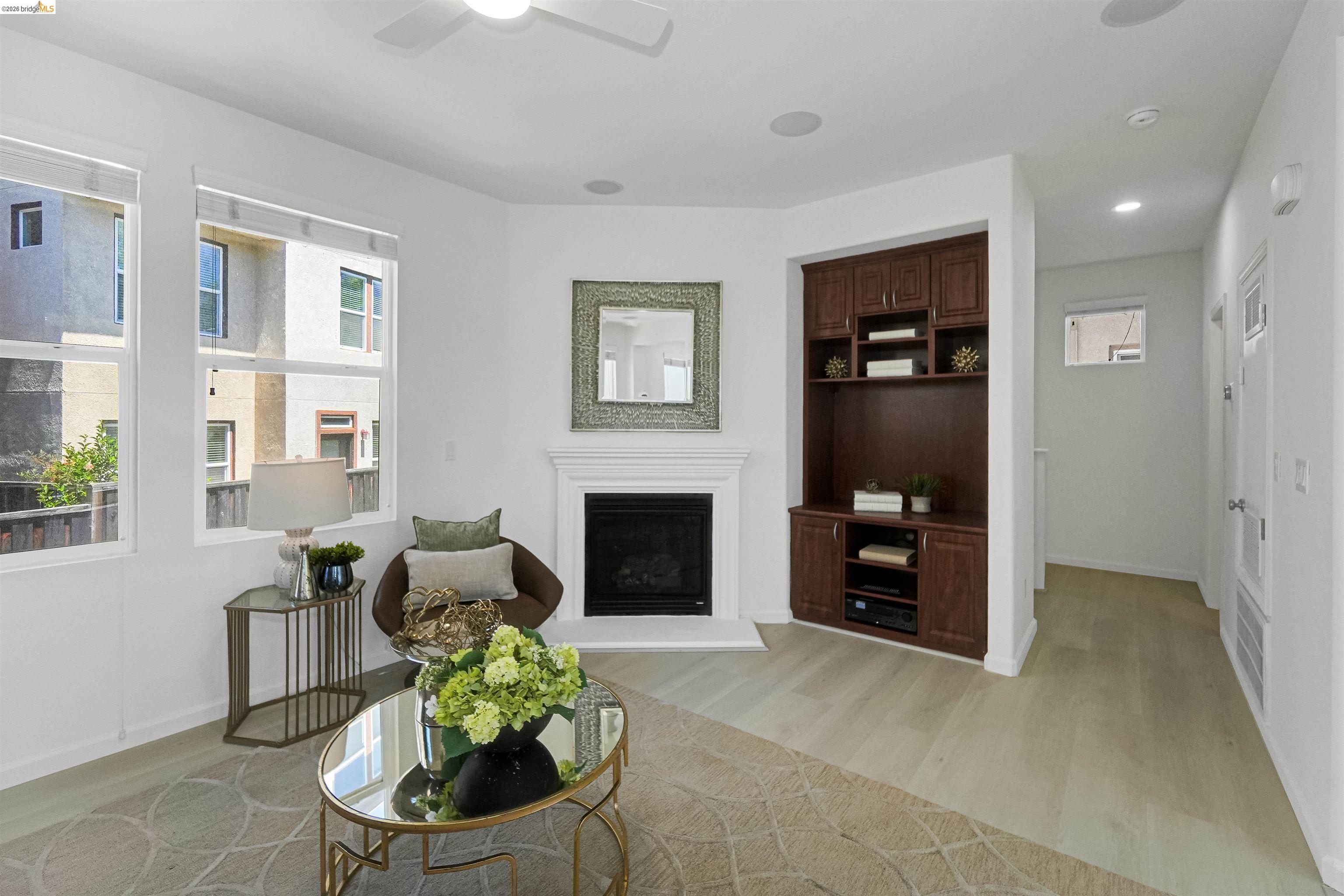 449 Constantine Court San Ramon, CA 94583 - Photo 17 of 63 Living area featuring light wood-finish flooring, a white mantel fireplace, a built-in entertainment center with rich wood cabinetry, multiple windows, and recessed lighting