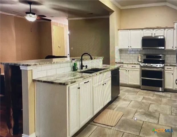a kitchen with stainless steel appliances granite countertop a sink and a stove top oven with granite countertops