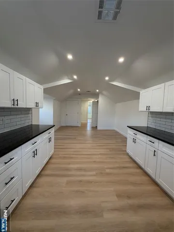 a large kitchen with stainless steel appliances wooden cabinets and granite counter tops