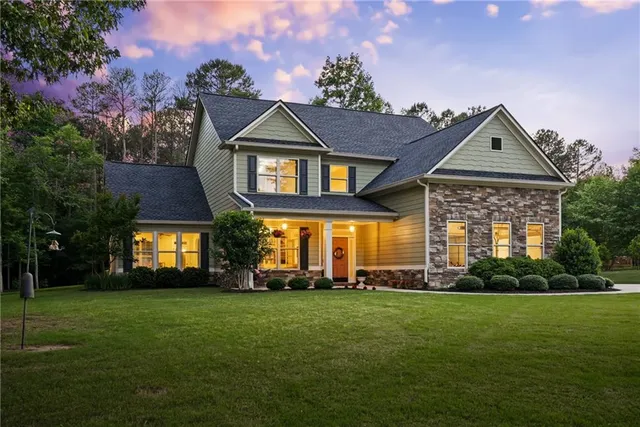 a front view of a house with a yard and trees