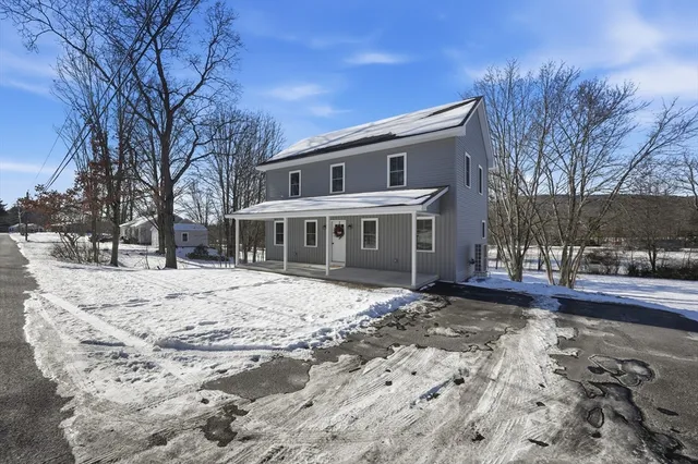 a front view of a house with a yard covered in snow