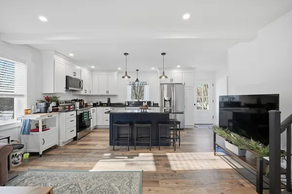 a kitchen with stainless steel appliances kitchen island granite countertop a refrigerator and a stove top oven