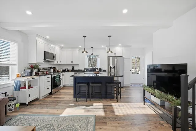 a kitchen with stainless steel appliances kitchen island granite countertop a refrigerator and a stove top oven