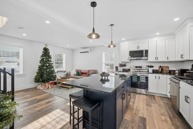 a kitchen with a sink chandelier and living room view