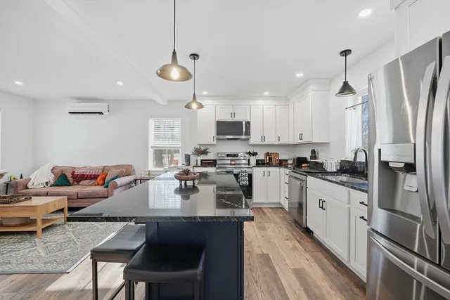 a kitchen with refrigerator and chairs