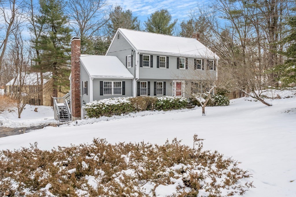 460 Littlefield Road Boxborough, MA 01719 - Photo 27 of 41 a front view of a house with a yard covered with snow and trees
