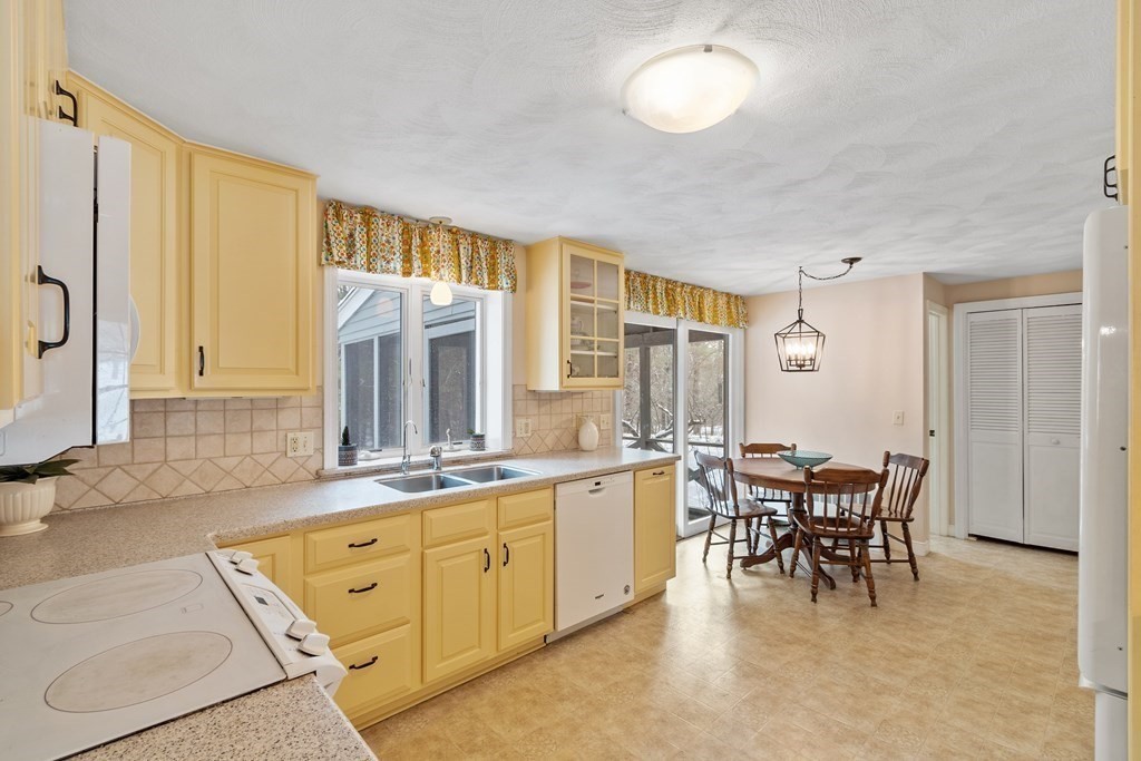 460 Littlefield Road Boxborough, MA 01719 - Photo 7 of 41 a large kitchen with kitchen island a large window and chairs