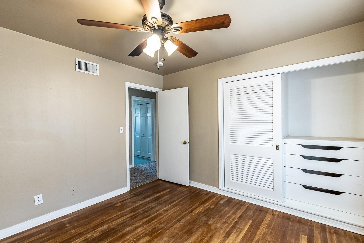 3708 27th Street Lubbock, TX 79410 - Photo 21 of 23 an empty room with wooden floor closet ceiling fan and windows
